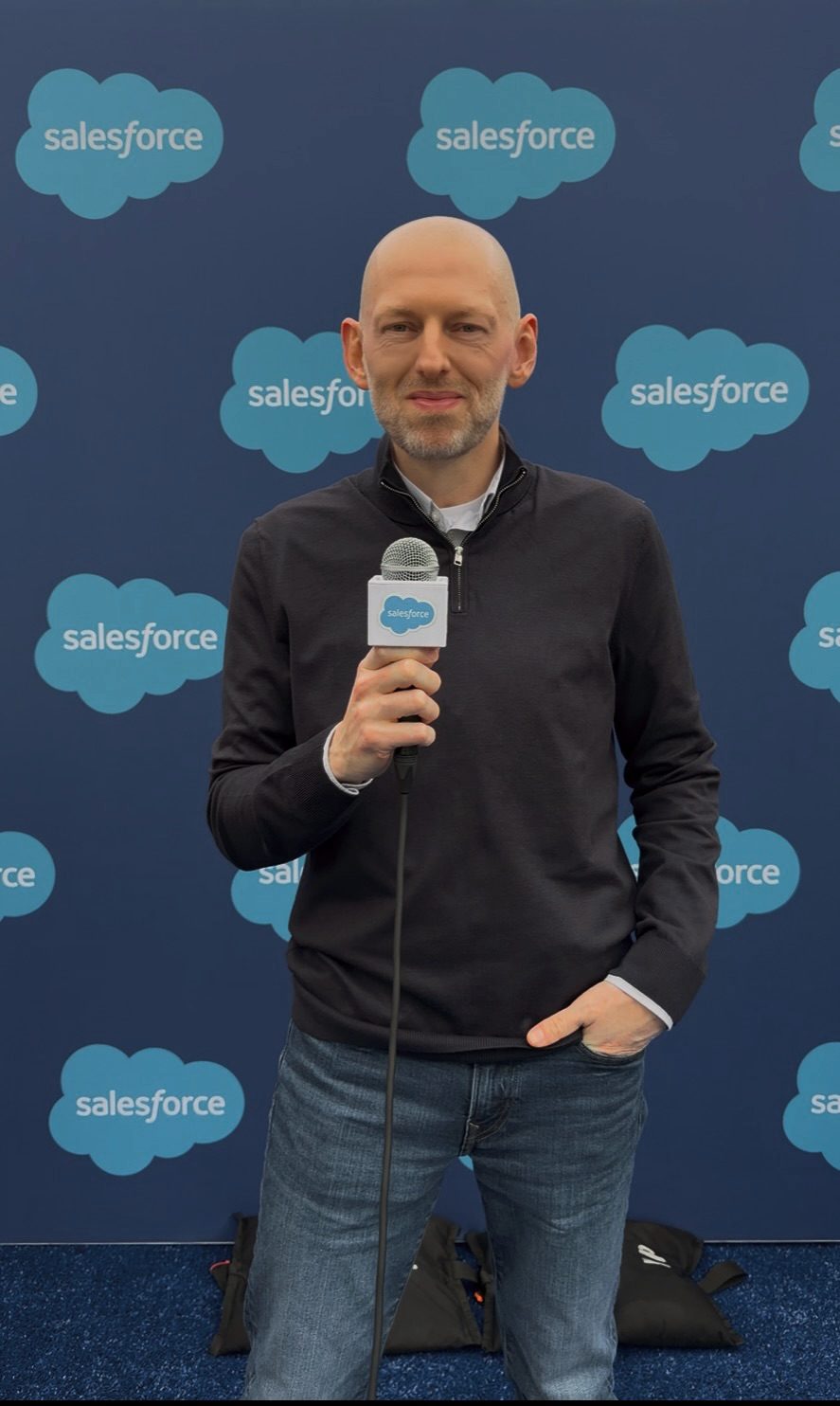 Daniel speaking on stage with a microphone at a Salesforce event